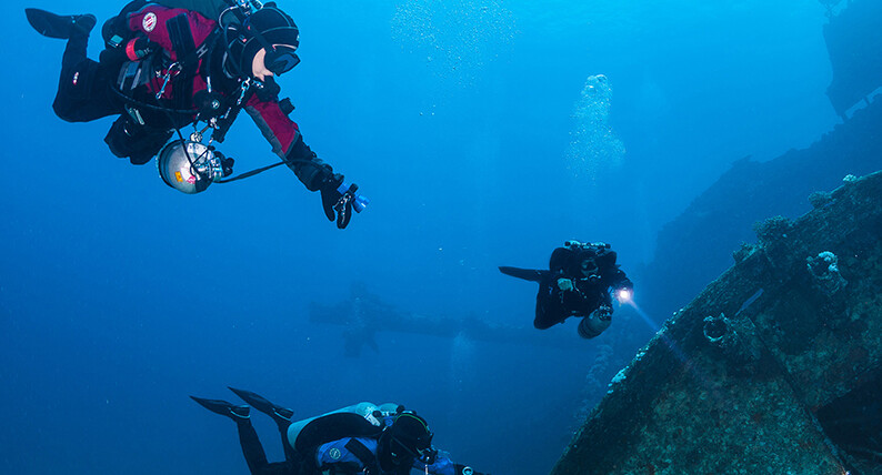 Scuba divers going to a sunken ship